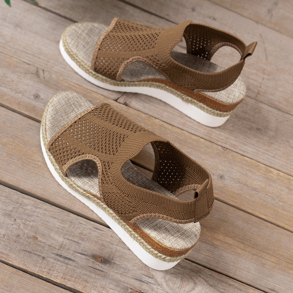 Pair of brown sandals on a wooden surface